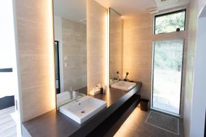 ein Badezimmer mit zwei Waschbecken und einem Spiegel in der Unterkunft GLテラス in Kyonan