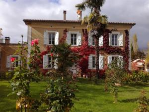 a house covered in ivy with a palm tree at Pause Campagne - Chambres d'Hôtes in Pouy-de-Touges