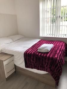 Un dormitorio con una cama con una manta morada. en Luxury Lavish Studio Apartments LE1, en Leicester