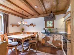 a kitchen with wooden ceilings and a table and chairs at Wagstaett Loft by Apartment Managers in Jochberg