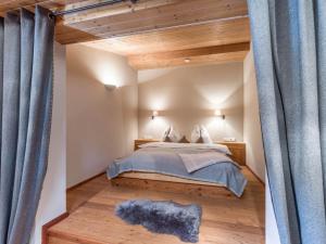 a bedroom with a large bed with blue curtains at Wagstaett Loft by Apartment Managers in Jochberg