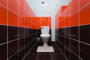 een badkamer met een toilet met oranje en zwarte tegels bij Apart Prokof'yeva in Sumy