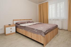een slaapkamer met een groot bed en een raam bij Apart Prokof'yeva in Sumy