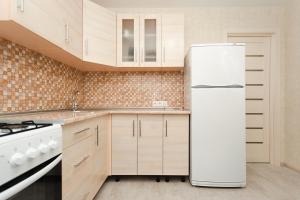 een keuken met een witte koelkast en een fornuis bij Apart Prokof'yeva in Sumy