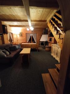 duży salon z kanapą i schodami w obiekcie Domki Szwajnosówka w mieście Witów