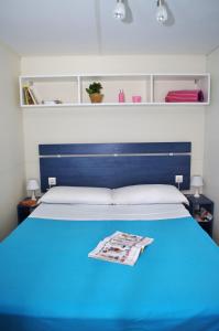 sypialnia z niebieskim łóżkiem z niebieskim zagłówkiem w obiekcie Happy Camp mobile homes in Camping Villaggio Lamaforca w mieście Carovigno +24 zdjęcia