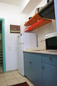 a kitchen with blue cabinets and a white refrigerator at Ρήγας: Όμορφα στο Μεσολόγγι, Διαμέρισμα Β2 in Missolonghi