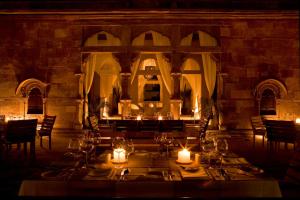 a dining room with a table with candles and lights at RAAS Jodhpur in Jodhpur