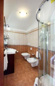 y baño con 2 aseos, lavamanos y ducha. en Casa Famiani Bed & Breakfast, en Letojanni