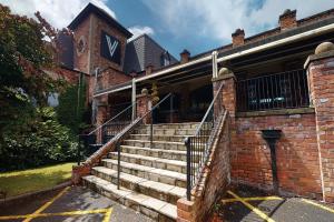 a brick building with stairs in front of it at Village Hotel Warrington in Warrington