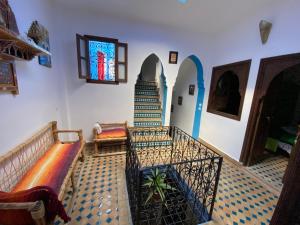 uma sala de estar com escadas e um vitral em Dar Essaouyry em Chefchaouene