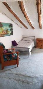 - une chambre avec un lit et une chaise dans l'établissement Casa De Juanita Vivienda Rural, à Hinojares