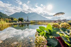 una vista di un lago con le montagne sullo sfondo di Alpendorf Hotel Stern a Sankt Johann im Pongau
