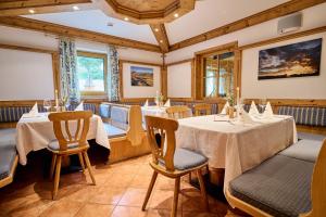 a dining room with two tables and chairs at Alpendorf Hotel Stern in Sankt Johann im Pongau