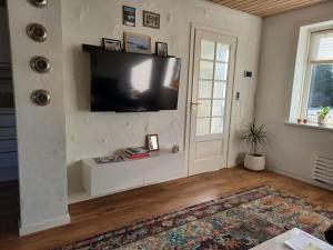 ein Wohnzimmer mit einem Flachbild-TV an der Wand in der Unterkunft "City Sleep" in Nykøbing Mors