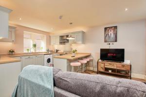 a living room with a couch and a kitchen at The Exquisite Harrogate Abode - Sleeps 6 in Harrogate