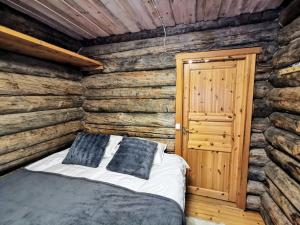 1 dormitorio con 1 cama en una cabaña de madera en Mäntyaho, en Syöte