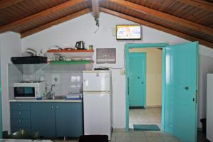 een keuken met blauwe kasten en een witte koelkast bij Ρήγας: Όμορφα στο Μεσολόγγι. Δ2 in Mesolongion