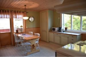 a kitchen with a table with chairs and a clock on the wall at Backnäsgården in Sandöverken