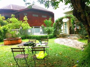 a yard with chairs and a table and a house at Lada House in Lampang