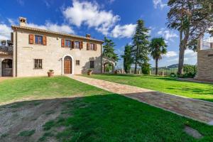an exterior view of a stone house with a driveway at Italian Experience-Villa Vagnini in Pesaro