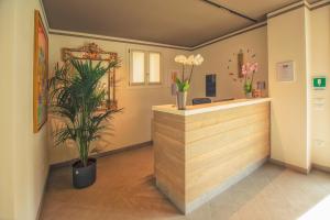 a lobby with a counter with plants and flowers at Hotel Residence Dolcenero in San Daniele del Friuli