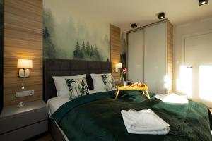 a bedroom with a large bed with a green blanket at Apartamenty Perłowa Przystań by Renters in Kołobrzeg