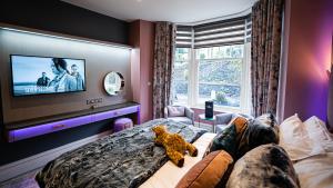 un dormitorio con un osito de peluche sentado en una cama en The Cranleigh Boutique, en Bowness-on-Windermere