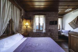 Un dormitorio con una cama grande y una ventana en Cunda Tas Konak Otel, en Ayvalık