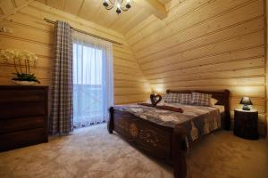 a bedroom with a bed and a window in a room at Domki Dream House ,,Jędruś" in Poronin