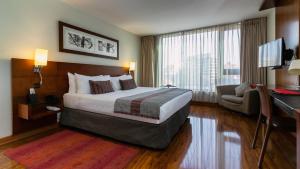 a hotel room with a large bed and a desk at Select by Time in Santiago