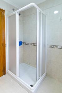 a bathroom with a shower with a glass door at Playa de Llas in Foz