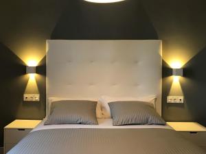 a bedroom with a white bed with two pillows at Apartamentos Ciudad de Ronda in Ronda