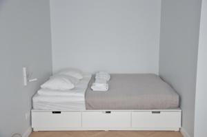 a bed in a room with a white wall at Vytautas Park Apartment with FREE Parking in Marijampolė