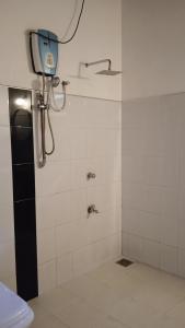 a bathroom with a shower with a camera on the wall at Gems Garden Guest House in Tangalle