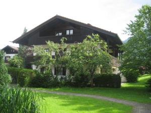 uma casa grande com um jardim verde em frente em Ferienwohnanlage Hochgern em Unterwössen