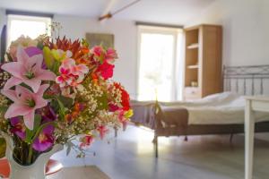 un jarrón de flores en una habitación con cama en Huisje en B&B Green Cottage, en Groesbeek
