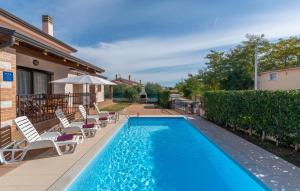 a swimming pool with chaise lounge chairs next to a house at Villa Leonie with Private Pool in Nova Vas