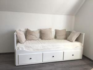 ein weißes Bett mit Kissen auf dem Zimmer in der Unterkunft Apartment in der Waldstraße in Vellberg