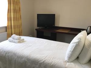 a bedroom with a bed with a desk and a television at PREMIER HOTEL not Premier Inn in Skegness