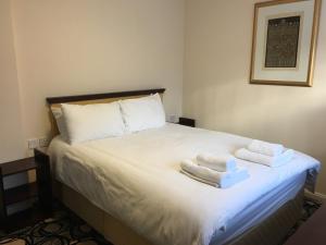 PREMIER HOTEL not Premier Inn في سكيجنيس: غرفة نوم عليها سرير وفوط