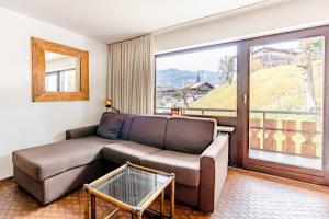 a living room with a couch and a large window at Huflattich in Obermaiselstein