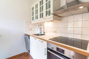 a kitchen with white cabinets and a sink at Huflattich in Obermaiselstein
