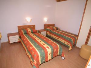 two beds in a hotel room with two bedsskirts at Villas Oleandri in Vrboska