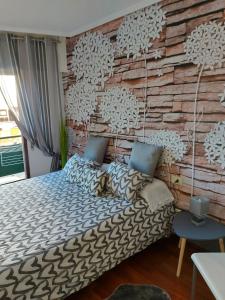 - une chambre avec un lit et un mur en briques dans l'établissement Estancia acogedora en Vigo, à Vigo