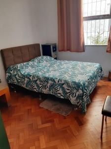 um quarto com uma cama com um cobertor verde em Hangar Rio Hostel no Rio de Janeiro