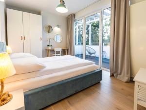 1 dormitorio con 1 cama grande y balcón en VacationClub – Orłowska Riwiera Apartament A6, en Gdynia