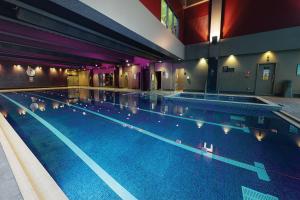 a large swimming pool in a large building at Village Hotel London Watford in Elstree