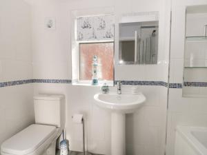a white bathroom with a toilet and a sink at Sally's Berth in Scarborough +10 photos
