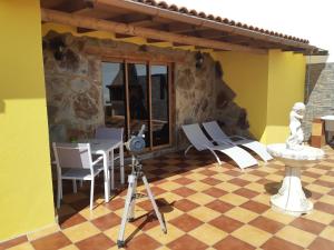 Cruce de Arinaga的住宿－Casa Guanche，一张三脚架上的摄像头,放在一张桌子和椅子上